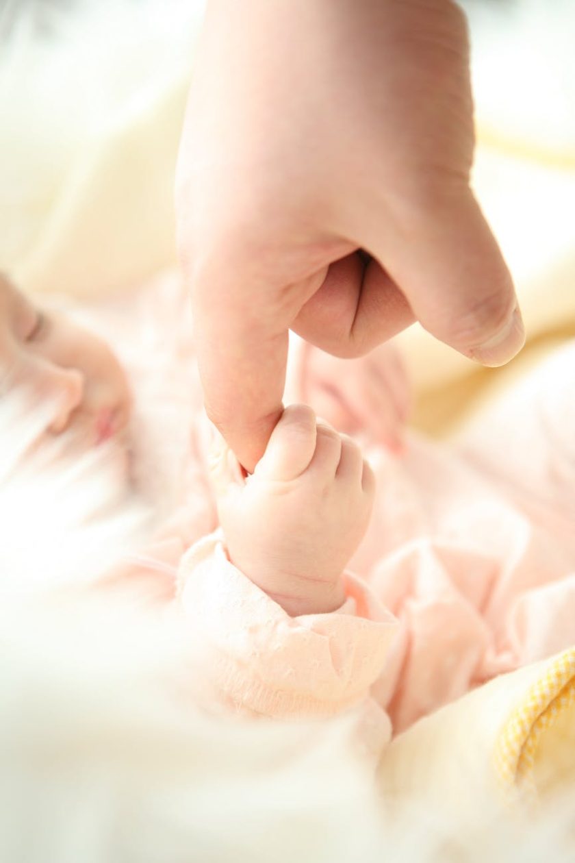 baby holding person s index finger